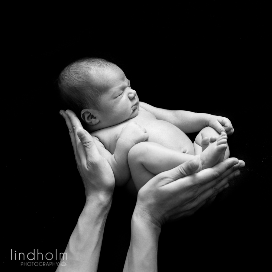 nyföddfoto av bebis i mamms händer